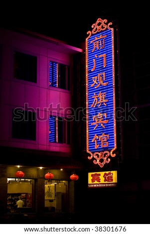 neon sign hanging on a building at night