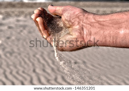 Sand falling from the old man\'s hand