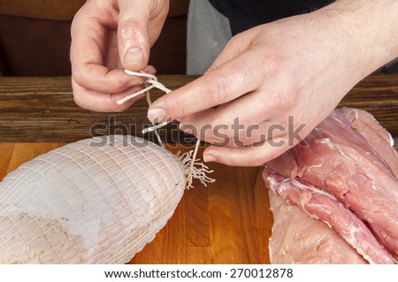 making meats - men\'s hands are doing ham