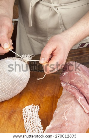 making meats - men\'s hands are doing ham