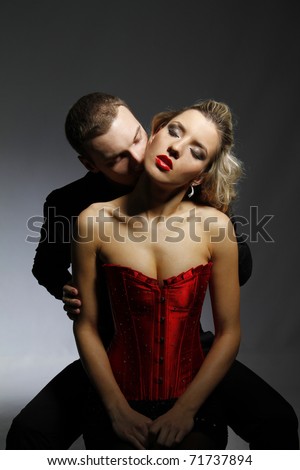 man kissing woman in her neck