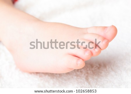 Baby\'s pretty leg on the white soft cover
