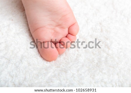 Baby\'s pretty leg on the white soft cover