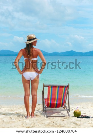 Beautiful Young woman in hat sunbathing on tropical beach