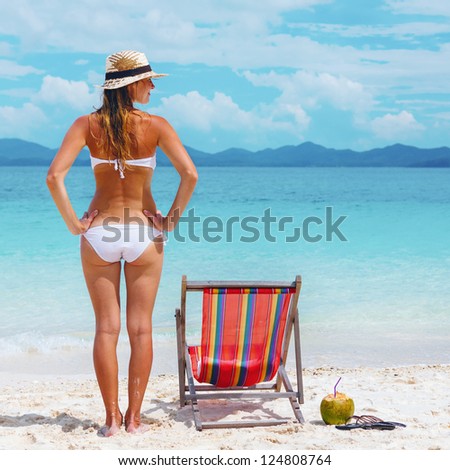Beautiful Young woman in hat sunbathing on tropical beach
