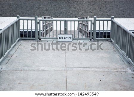 Gray metal fence with a sign to protect the pier