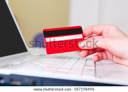 Woman holding a credit card for online shopping.