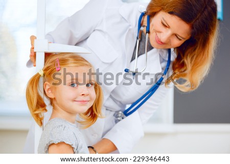Doctor measuring height of a cute redhead girl Doctor measuring height of a cute redhead girl