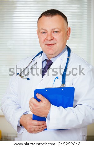 Doctor with stethoscope around his neck looking at the camera.