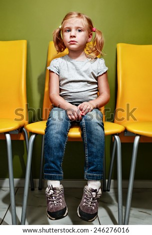 Little redhead girl waiting in reception room.