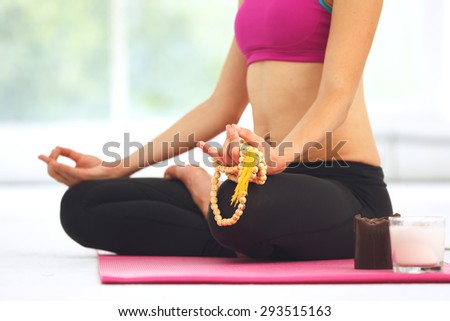 Young beautiful woman meditating in lotus pose.