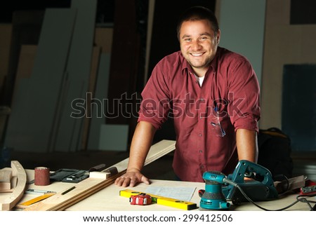 Portrait of happy professional carpenter at his work place.