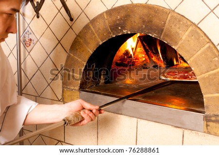 Baked pizza by the fire in traditional oven