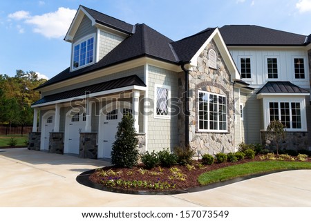 Large suburban house exterior with tree car garage