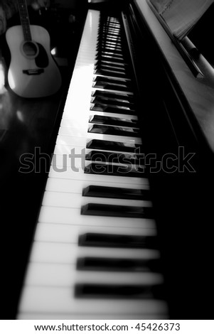 Piano keyboard closeup with guitar
