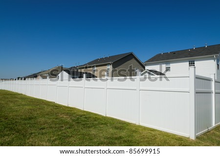 Suburban landscape with a long vinyl fence