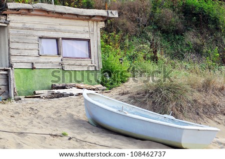 an old shack by the sea and the boat.