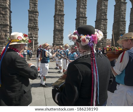 SEGOVIA  SPAIN - MARCH 16 2014 - East Suffolk Morris Men dancing in the Roman city of Segovia, Spain with blue and white uniform, bells and straw hats  with flowers.  Traditional English folk dancing.