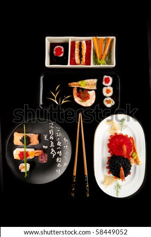 Several elegant sushi dishes with norimaki and nigiri sushi, a variety of colourful fish eggs a selection of plates and chopsticks. On black.