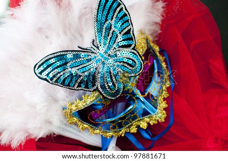 Venetian style sequinned carnival  mask with a butterfly and feathers.