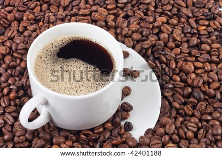 cup of coffee over a lot of coffee beans background