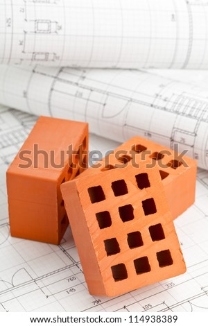 Brick stones on home construction blueprints - house building or construction concept