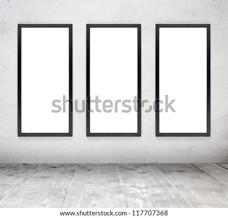 Empty white old interior room with painted concrete wall and empty black wood frames and wooden plank floor