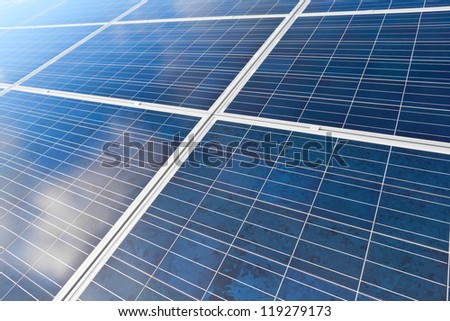 Solar photovoltaics panels field for renewable energy production with blue sky and clouds