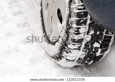 Car tire on snowy road close up