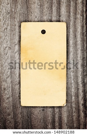 Brown paper vintage clothing label on wooden background
