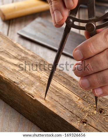 Carpenter measuring on old block of wood in craftsman\'s shop