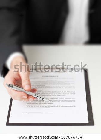 Businessman holding pen for signature on contract