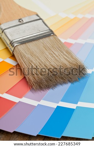 Color chart guide for renovation with brush on wooden surface
