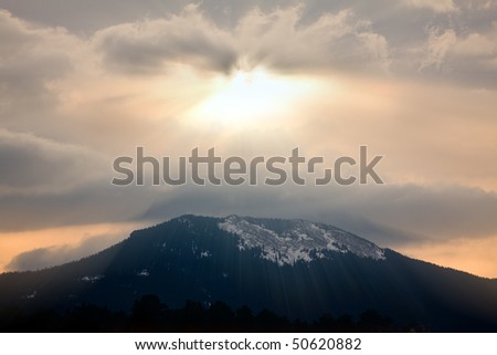 God rays during sunset over mountain silhouette