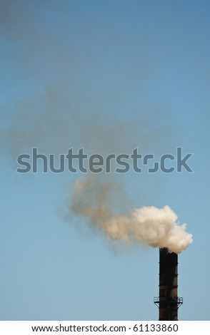 Smoke stack with smoke cloud on blue sky