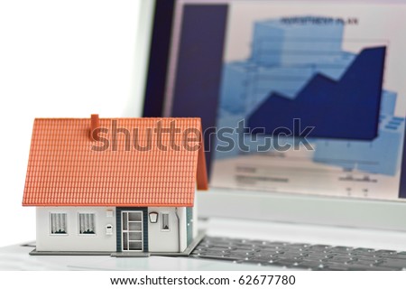 Model house in front of computer with financing plan - mortgaging or home financing concept
