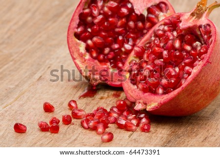 Delicious pomegranate with seeds on wooden table