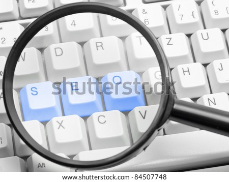 SEO - search engine optimization concept with the letters s, e, o on a computer keyboard seen through a magnifying glass