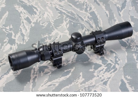 rifle scope on camouflaged background