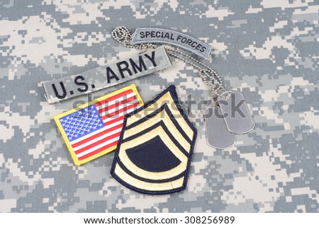 KIEV, UKRAINE - August 21, 2015. US ARMY Sergeant First Class rank patch, special forces tab, flag patch,  with dog tag on camouflage uniform