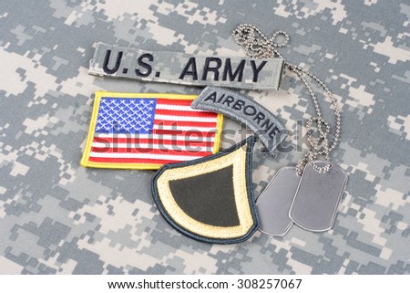 KIEV, UKRAINE - August 21, 2015. US ARMY Private First Class rank patch, airborne tab, flag patch,  with dog tag on camouflage uniform