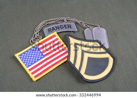 KIEV, UKRAINE - August 21, 2015.  US ARMY Staff Sergeant rank patch, ranger tab, flag patch and dog tag on olive green uniform