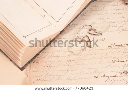 Vintage background with old books,handwriting papers and retro eyeglasses