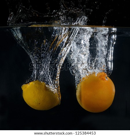 Orange and lemon splash on black background
