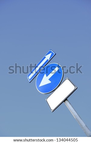 Road sign with two arrows and free banner for text on a deep blue sky