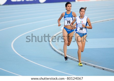 TURIN, ITALY - JUNE 26: Fatna Maraoui (No. 74) and Elena Romagnolo (No. 79) run 5,000m women\'s race at 2011 Track and Field Italian Championship on June 26, 2011 in Turin, Italy.