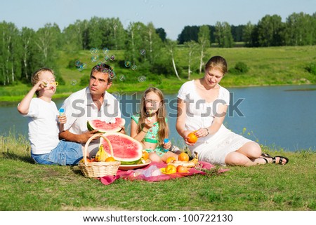 family resting on the lake