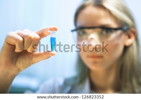 young woman holding a plastic test tube