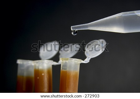 Laboratory tubes and dropper on the dark background