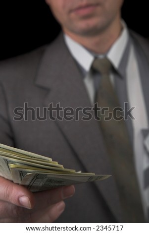 man, giving money, isolated on black. Focus on the dollars